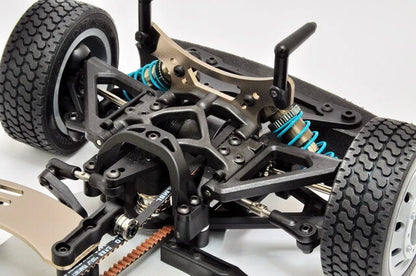 Close-up of a detailed model car chassis with suspension and wheels on a white background